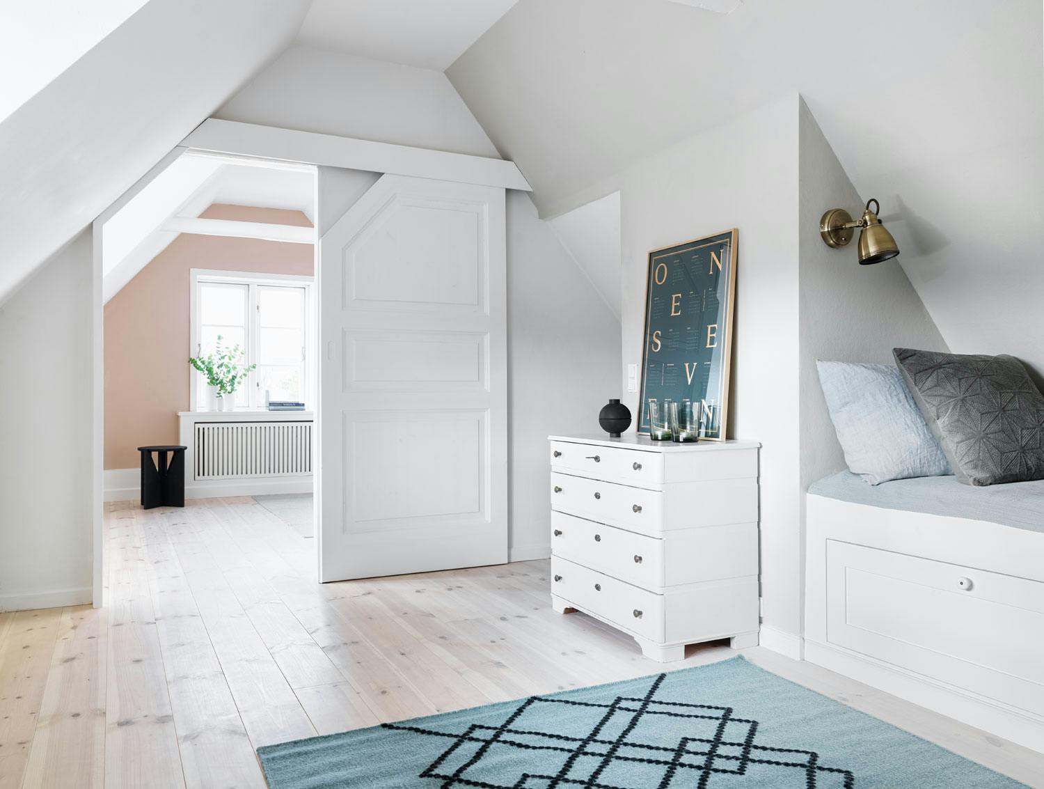 Plassbesparende skyvedører mellom rommene Hvitt loft med gode oppbevaringsløsninger og skreddersydde skyvedører mellom rommene
